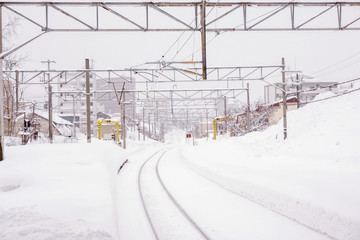 Cityscape view and closeup metal long railroad track in winter season and snow capped city with...