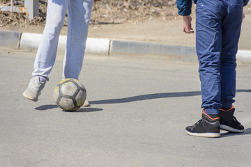 Children play dangerous football on the roadway. Street football. Road safety. Not safe pedestrian behavior. Ulyanovsk, Russia.