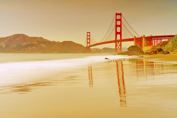 View of Golden Gate Bridge from Marshall's Beach in San Francisco at sunset.