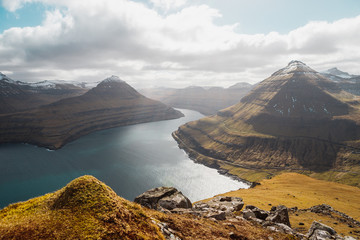 Spectacular views of the scenic fjords on the Faroe Islands near the village Funningur with snow-covered mountains during a sunny spring day (Faroe Islands, Denmark, Europe)