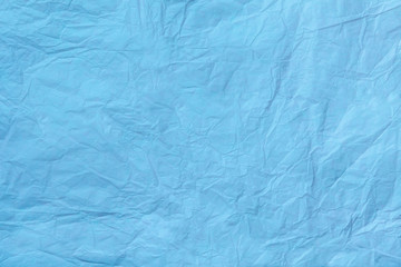 Fototapeta premium Texture of crumpled light blue wrapping paper, closeup. Turquoise old background.