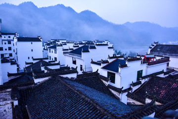 Fototapeta premium Chinese Traditional Characteristic Mountain Village Architectural Landscape in Morning Fog