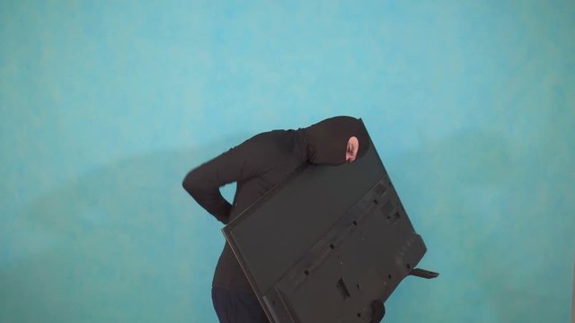 anonymous thief in a Balaclava mask,experiencing back pain