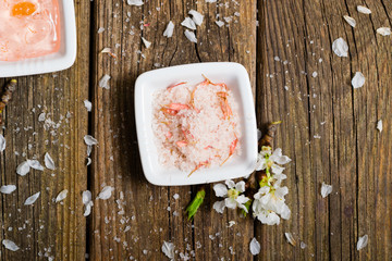 cosmetics and cherry blossom on old wooden table background