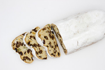 The three slices and the main part of Stollen isolated on a white background. Traditional German Christmas cake with marzipan and dried fruits.