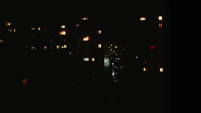 Night time lapse of Light in the windows of a multistory building. life in city