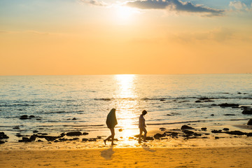 Fototapeta na wymiar Sunset landscape with beach, sun and stones at sea shore