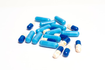 Medicine color pills or capsules on white background with copy space. Drugs macro photo. Drug...