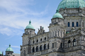 Amazing architecture of a historic neo-baroque British Columbia Parliament building. Emerald colored domes and wonderful statues on the roof, Victoria, Canada