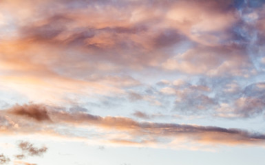 Fluffy pink clouds against a blue sky at sunset