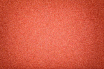 Fototapeta premium Dark orange matt suede fabric closeup. Velvet texture of felt.