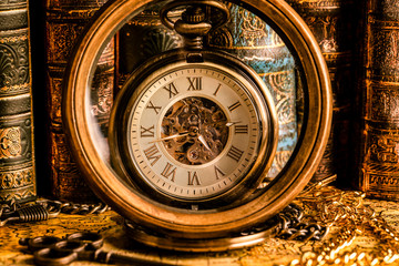 Fototapeta na wymiar Antique clock on the background of a magnifying glass and books. Vintage style. 1565 old map of the year.