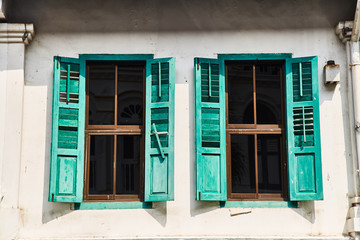 Windows with vintage shutters against a white wall