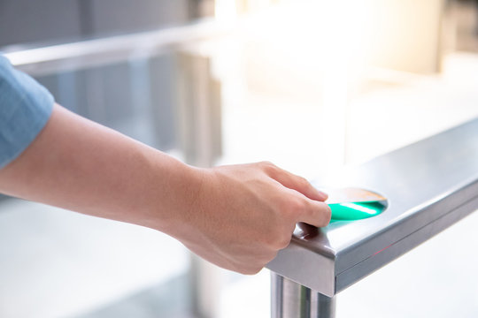 Male hand using smart card to open automatic gate machine in office building