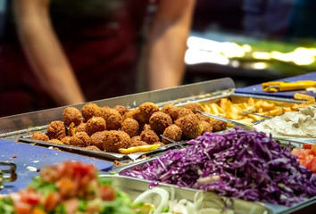 Falafel store counter, Falafel balls and chopped vegetables in bowls on a store desk