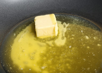 Piece of melting butter on frying pan, closeup