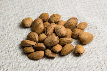 Almonds nut in shell on beige fabric texture