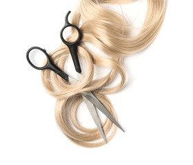 Curly blond hair and scissors on white background, top view. Hairdresser service