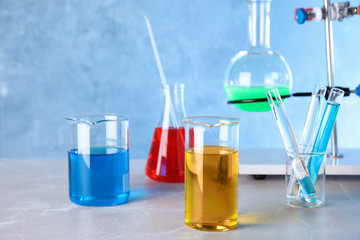 Different glassware with samples on table in chemistry laboratory