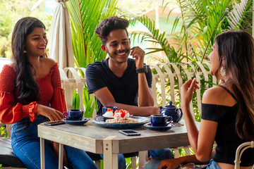 Multicultural group of people discussing by laptop in summer cafe surfing online freelancer...