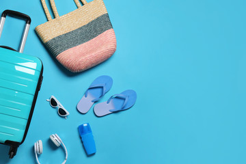 Flat lay composition with suitcase and accessories on color background, space for text. Summer vacation