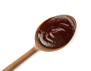 Spoon with hot barbecue sauce on white background