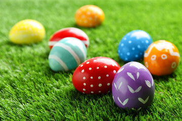 Fototapeta na wymiar Colorful painted Easter eggs on green grass, space for text