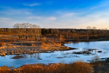 Fototapeta premium Dramatic sunset on the banks of the city pond. Spring landscape.