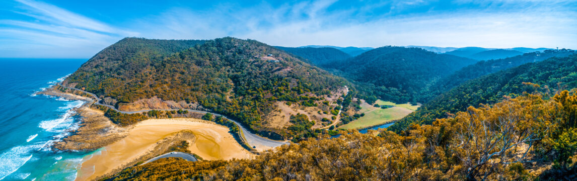 Wide aerial panorama of Great Ocean Road and hills near Lorne on bright sunny day