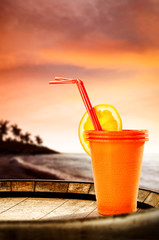 Summer drink on wooden barrel and sunset time. Sea and beach landscape with palms and free space for your bottle. 