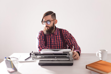 Fototapeta na wymiar people, writer and hipster concept - young stylish writer working on typewriter