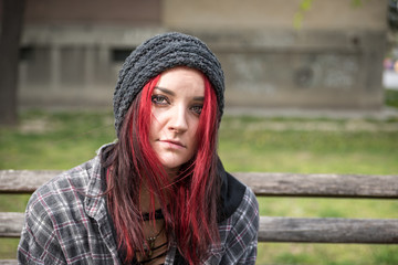 Homeless girl, Homeless Young beautiful red hair girl sitting alone outdoors on the wooden bench on...