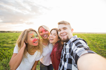 Portrait of happy friends on holi color festival taking selfie