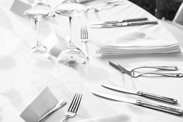 Elegant table setting: white plates with white linen and silverware. Weddingor festive dinner table set up