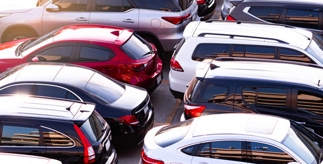 Car parked at concrete parking lot of shopping mall in holiday. Aerial view of car parking area of the mall. Automotive industry. Automobile parking space. Global automobile market concept. - obrazy, fototapety, plakaty