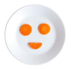 Smiley face made of vegetables on a plate, carrot smiley vegan raw food