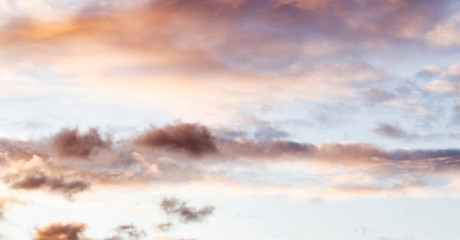 Fluffy pink clouds against a blue sky at sunset