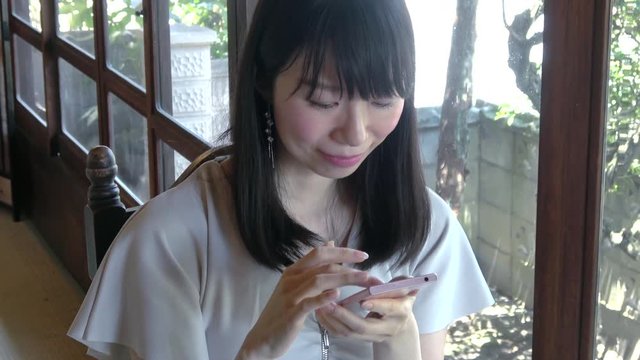 スマートフォンを使う若い女性 /  Young Asian woman using the smartphone, 4K