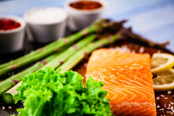Fresh raw salmon fish served on black stone on wooden table