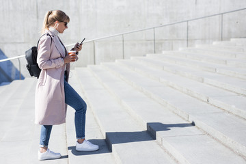 success and career concept - side view of young woman walking up the stairs