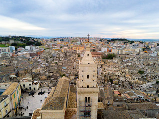 Naklejka premium Aerial Panoramic View of the Belltower of the Cathedral of St. Maria La Bruna on Cloudy Sky at Sunset