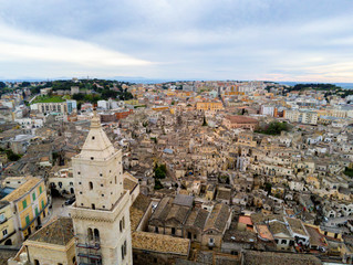 Naklejka premium Aerial Panoramic View of the Belltower of the Cathedral of St. Maria La Bruna on Cloudy Sky at Sunset