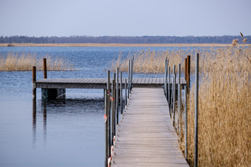 Naklejka premium drewniana deska ścieżka podnóża trampolina w jeziorze