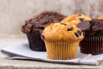 Homemade muffins with chocolate, vintage background.