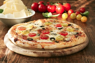 Homemade Pizza with tomatoes, olives and gouda cheese