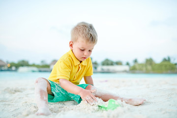 Three year old toddler playing on beach