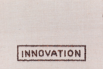Innovation sign from coffee beans isolated on linea texture bottom center.