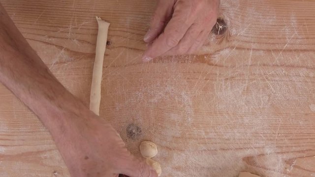 Pasta fatta in casa su un tagliere di legno con farina bianca e integrale.
