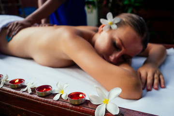 Plakat Ayurveda indian woman having relaxing body asia spa treatment india flowers and candles