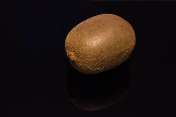 Whole Kiwi fruit against a black background